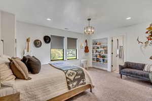 Bedroom featuring an inviting chandelier and carpet