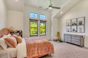 Bedroom with carpet flooring, ceiling fan, and a high ceiling