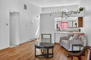 Sitting room with light wood-style floors and a baseboard heating unit