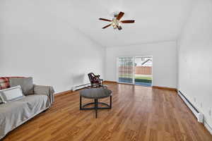 Sitting room with a baseboard radiator, wood finished floors, a ceiling fan, and baseboard heating