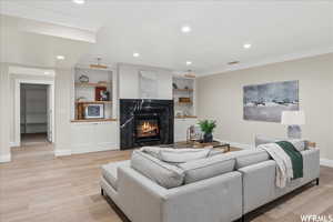 Living room featuring ornamental molding and light hardwood / wood-style flooring