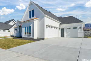 View of front of home with a front yard and a garage