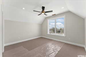 Bonus room featuring light colored carpet, lofted ceiling, and ceiling fan