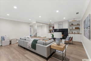 Living room featuring light wood-type flooring and crown molding