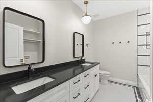 Full bathroom with tile patterned flooring, toilet, tiled shower / bath, and vanity