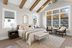 Bedroom with carpet floors and vaulted ceiling with beams