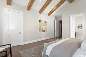 Bedroom featuring lofted ceiling with beams and connected bathroom