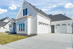 View of front facade featuring a garage and a front lawn