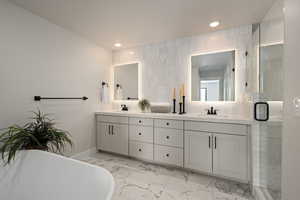 Bathroom with tile walls, independent shower and bath, and vanity