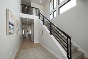 Stairway featuring hardwood / wood-style flooring and a high ceiling