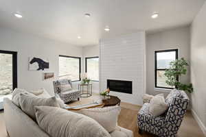 Living room with a fireplace and light wood-type flooring