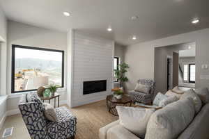 Living room featuring a large fireplace and light hardwood / wood-style flooring