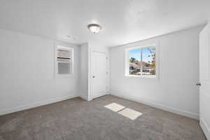 Unfurnished bedroom featuring a textured ceiling and carpet