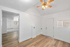 Clothes washing area featuring light wood-type flooring, electric dryer hookup, a textured ceiling, hookup for a washing machine, and ceiling fan