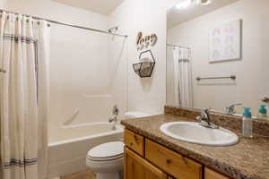 Full bathroom with vanity, toilet, and shower / tub combo with curtain