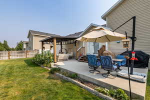 Back of house with a yard and a patio area