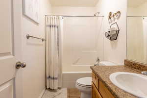 Full bathroom with shower / bath combo, tile patterned flooring, toilet, and vanity