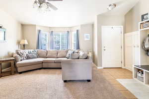 Living room with light tile patterned floors and ceiling fan