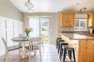 Kitchen featuring pendant lighting, plenty of natural light, light tile patterned floors, and sink