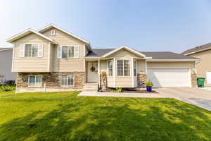 Split level home with a garage and a front yard