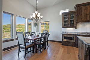 Dining room with light wood-type flooring, a chandelier, and a wealth of natural light