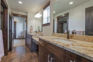 Bathroom with a shower with door, vanity, and tile patterned floors