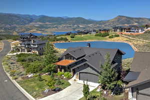 Birds eye view of property with a water and mountain view