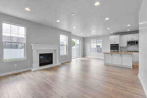 Unfurnished living room with sink and light hardwood / wood-style floors