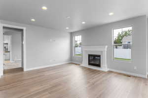 Unfurnished living room featuring light wood-type flooring