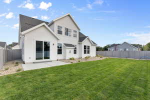 Rear view of property with a yard and a patio area