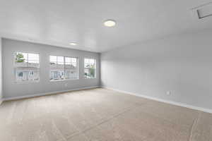 Carpeted spare room with a textured ceiling