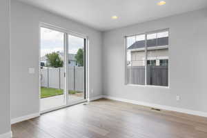 Unfurnished room featuring light wood-type flooring and a wealth of natural light