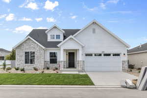 Craftsman house featuring a garage and a front yard