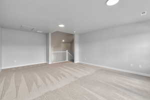 Unfurnished room featuring lofted ceiling and carpet