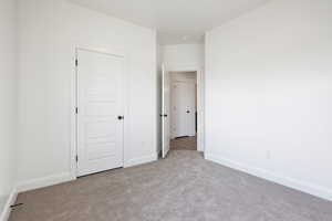 Unfurnished bedroom featuring light colored carpet