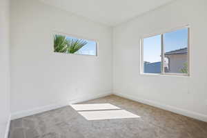 Carpeted spare room featuring a healthy amount of sunlight