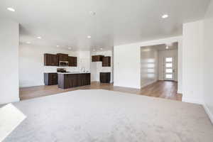 Unfurnished living room featuring light wood-type flooring and sink