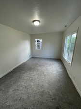 Carpeted empty room with a textured ceiling