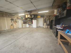 Garage featuring water heater and white fridge