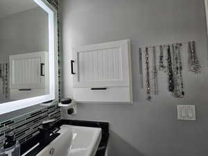 Bathroom featuring decorative backsplash and sink