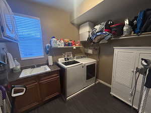 Laundry room featuring washer and dryer, dark hardwood / wood-style flooring, cabinets, and sink