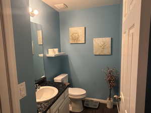 Bathroom with vanity, toilet, and hardwood / wood-style floors