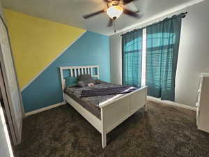 Bedroom featuring ceiling fan and dark colored carpet