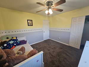 Bedroom with dark carpet and ceiling fan