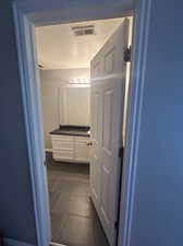 Bathroom featuring tile patterned flooring, a textured ceiling, and vanity