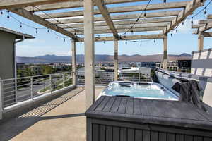 Rooftop deck with pergola, string lights, Bullfrog hot tub, and gas line for BBQ