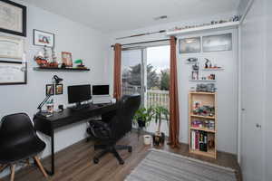 Office space with a textured ceiling and dark hardwood / wood-style floors