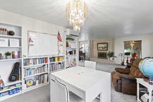 Carpeted dining space featuring a brick fireplace and a chandelier