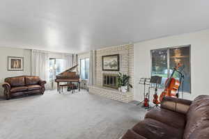 Carpeted living room with a brick fireplace