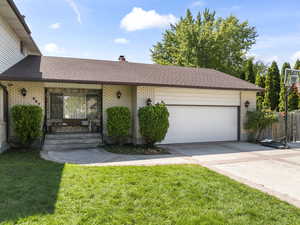 Ranch-style house featuring a front yard and a garage